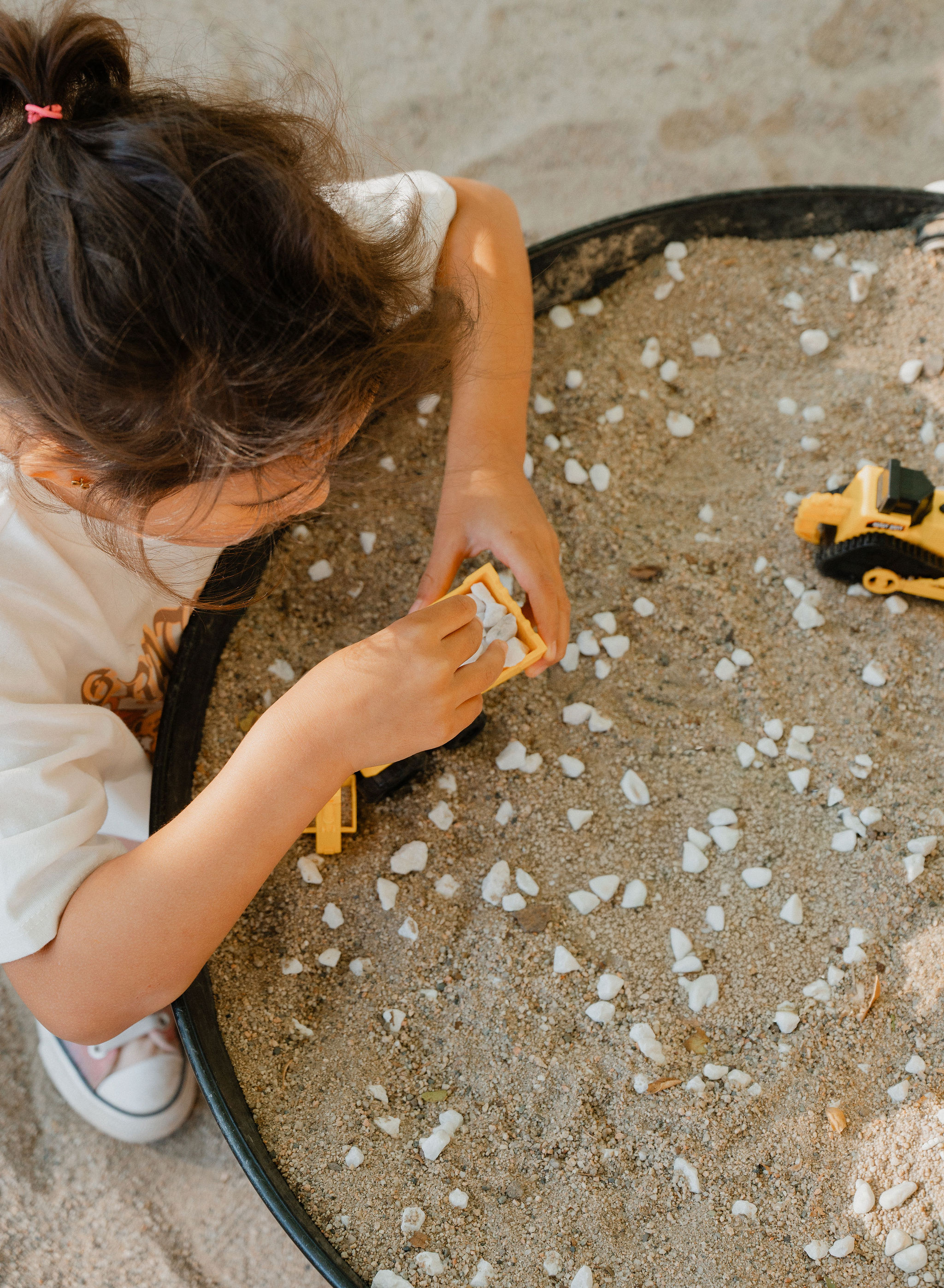 Child exploring natural materials outdoors at Orchard Atelier